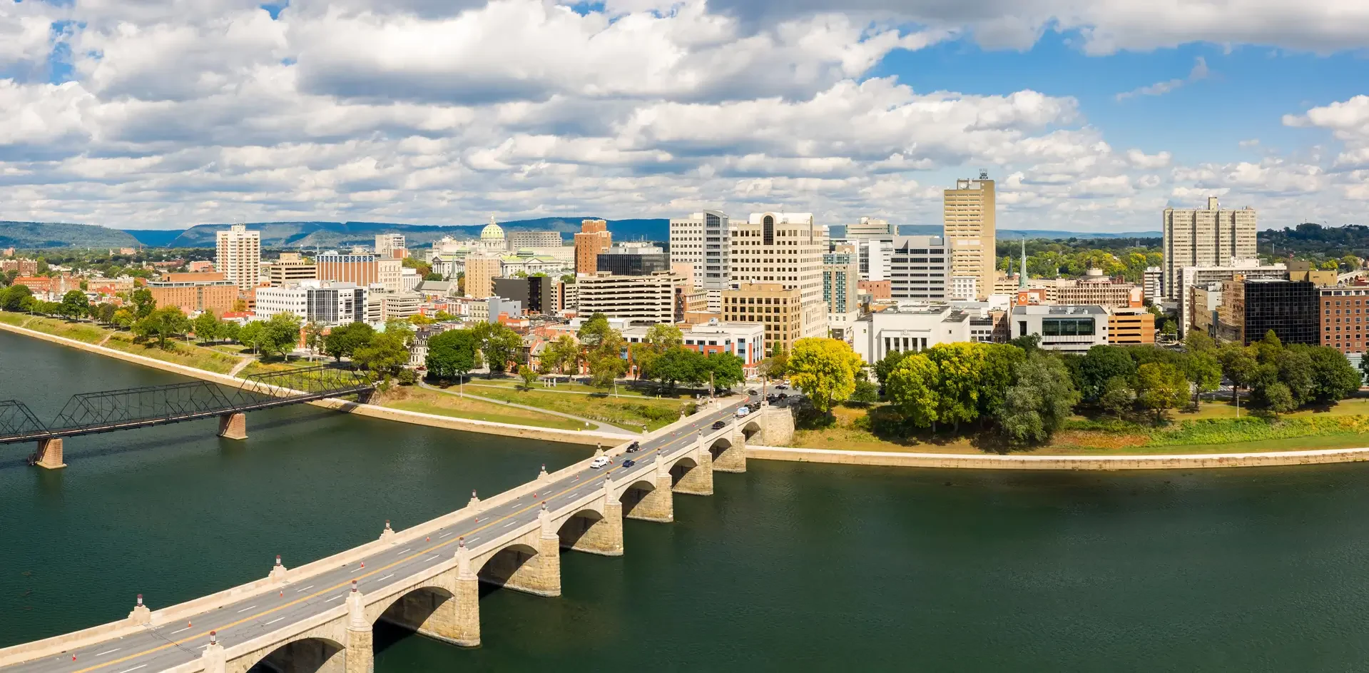 The cityscape of Columbia, South Carolina, featuring modern buildings and greenery against a bright sky