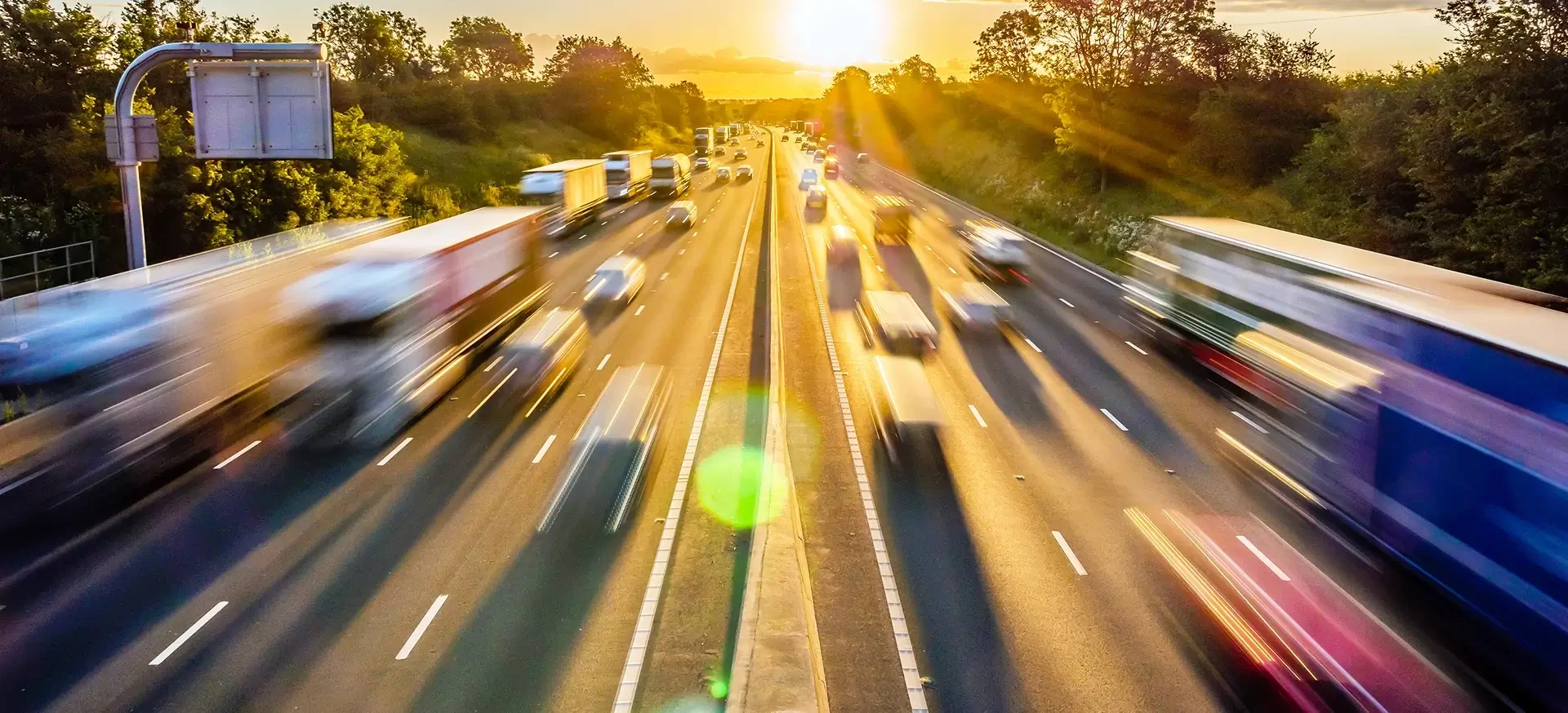 A highway scene featuring multiple cars driving along the road under a clear blue sky